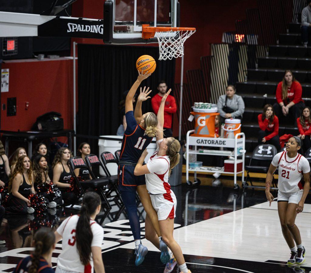 Senior guard Helena Friend attempts a layup over a CSUN defender Nov. 27 at Premier America Credit Union Arena. Friend also racked up double digits in points, 10, to go along with three blocks and a steal.