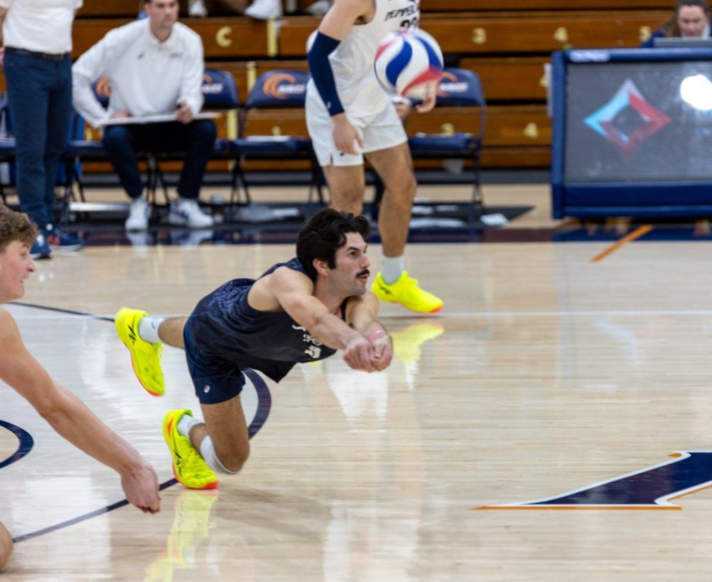 Junior libero Jacob Reilly dives for a dig in Firestone Fieldhouse on Feb. 8. Reilly had a total of eight digs and assisted the overall scrappiness of Pepperdine's defense.