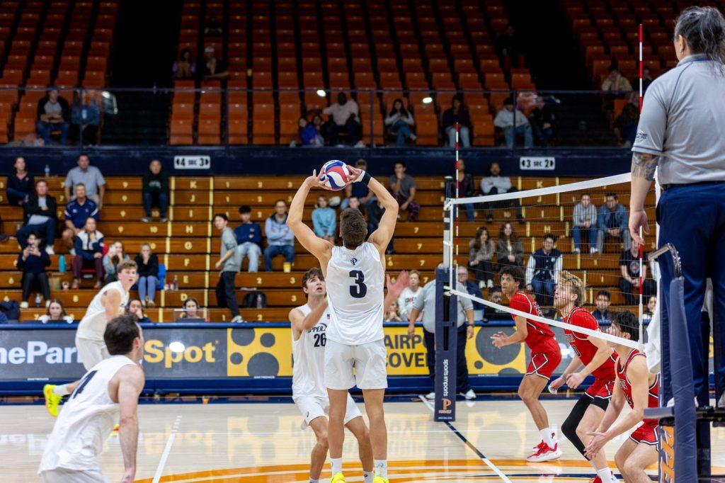 Graduate setter Gabe Dyer sets the ball to complete a kill in Firestone Fieldhouse on Feb. 8. Dyer had 43 assists throughout the game.