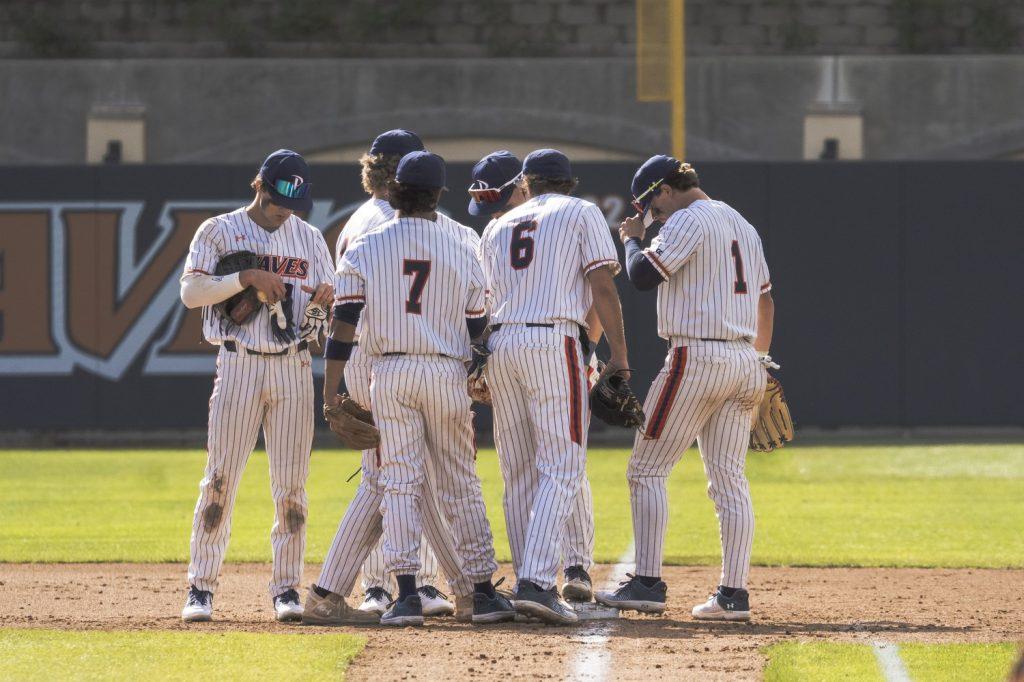 Waves middle infielders senior Julian Nunez (#7) and senior Justin Rubin (#12) huddle with their team during a matchup against Utah on Feb. 14, at Eddy D. Field Stadium. LaTorre said Pepperdine is notorious for having a strong middle infield presence, noting Nunez and Rubin as key players in the season moving forward.