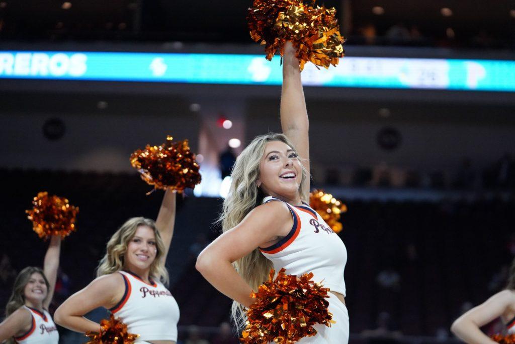 Senior cheerleader Georgia Puckett performs in Firestone Fieldhouse during Blue and Orange Madness on Oct. 4. Puckett said that Pepperdine Cheer has changed not only who she is as an athlete but also who she is as a person.