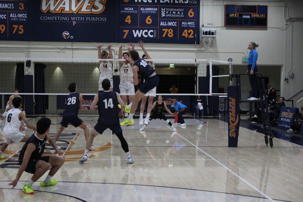 Pepperdine's defense covers Hartke as he attacks the ball to Loyola at Firestone Fieldhouse on Jan. 30. Hartke led the team in kills and solo blocks with one.