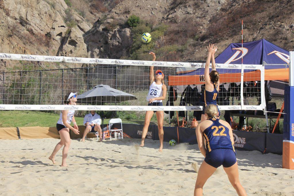 Junior Gabriella Perez spikes the ball against California State University, Bakersfield on Feb. 21 at the Pepperdine Beach Courts. Perez and graduate Marley Johnson fought a close one in the first set 21-19, but ultimately lost both sets against Bakersfield. Photos by Guinevere Hesse