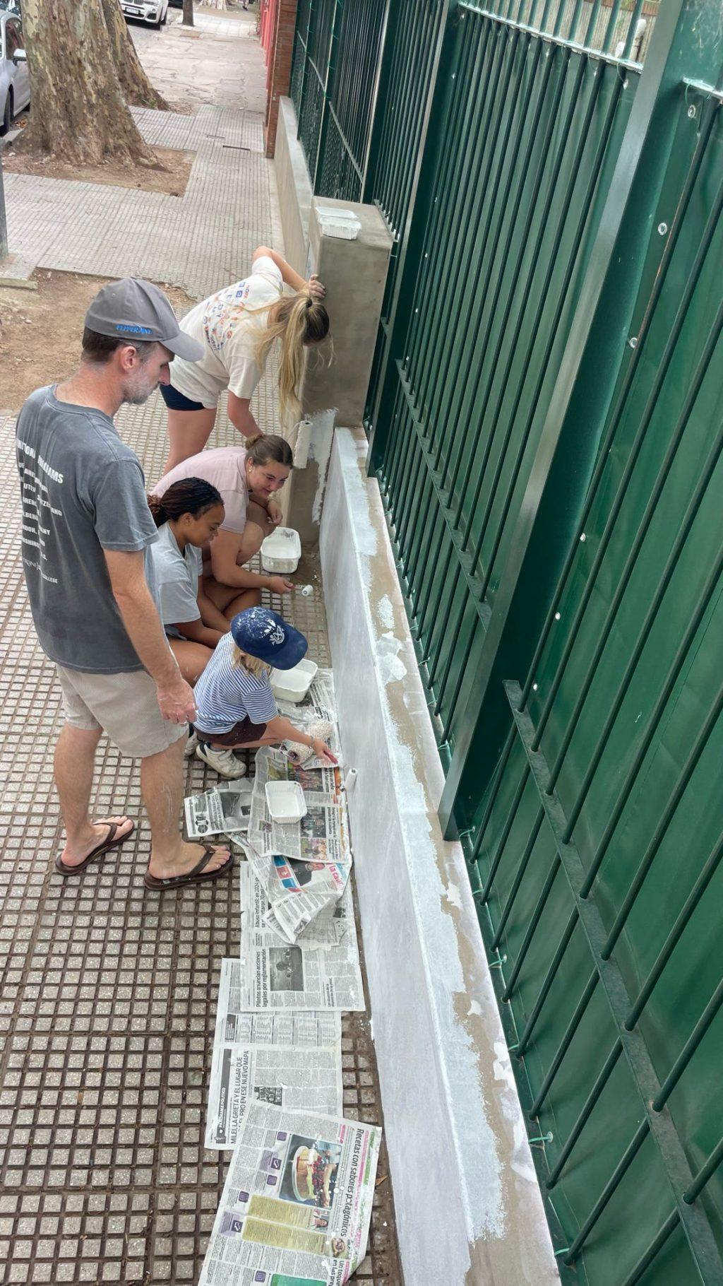 Nine students from the Buenos Aires International Program paint a fence of a local monastery Feb. 22. The program tries to offer multiple service opportunities a month for students to participate in, said Harmony Hill-Weber, the program’s Student Affairs and Spiritual Life Coordinator. Photo courtesy of Julie Joy Oliveira