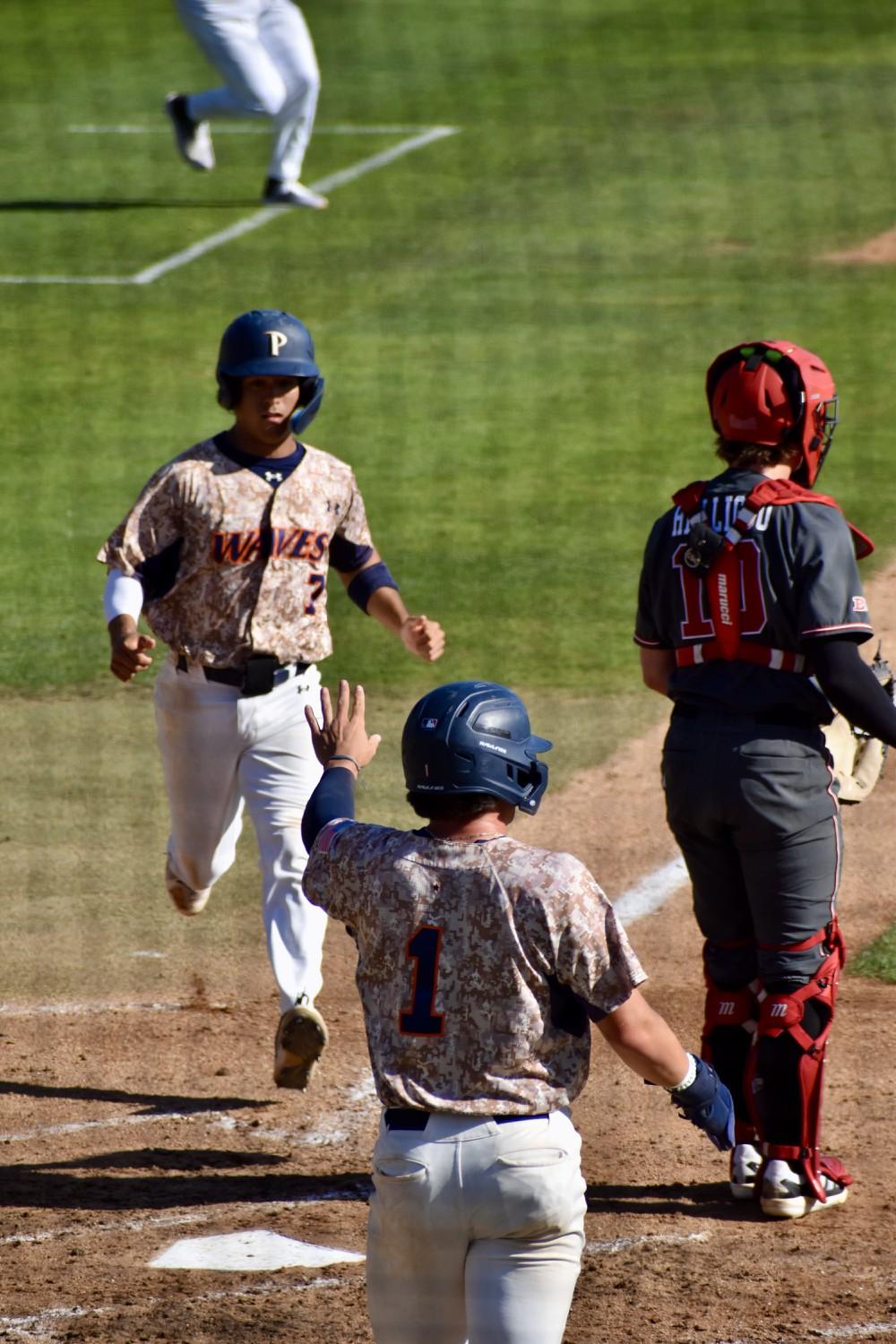 Senior infielder Julian Nunez crosses the plate with graduate outfielder Nick Upstill awaiting his arrival against Nebraska on March 19 at Eddy D. Field Stadium. Nunez has started every game for the Waves so far this season. Photo by Mary Elisabeth