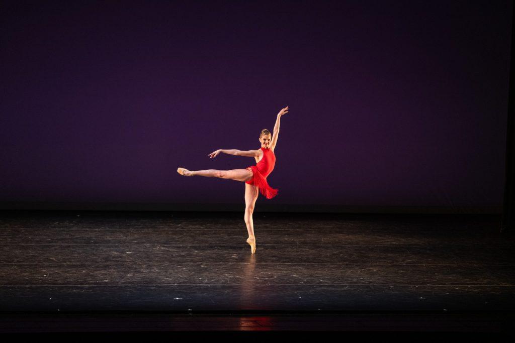 Natalie Steele strikes an arabesque during "More Than Nothing" on March 13. This piece contrasted the previous dance with its vibrant energy, bright costumes and lively, tango-inspired music. Photo courtesy of Matt Dine