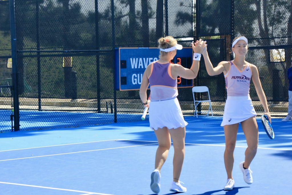 Freshmen Anastasiia Grechkina and Alexia Harmon high-five during their doubles match against the California Bears at the Ralphs-Straus Tennis Center on Feb. 22. The pair lost their match Feb. 22, but are ranked No. 39 in the country for doubles.