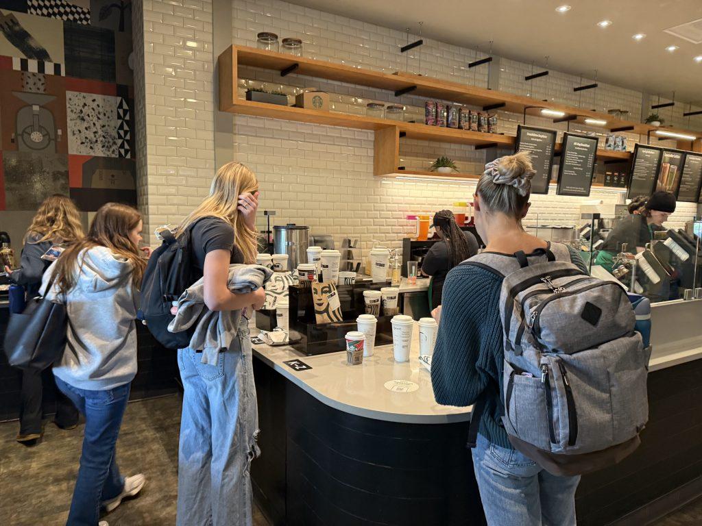 Students pick up their orders from the Starbucks in Payson Library on March 11. Grande, venti and trenta-sized drinks are now being served in the compostable cups, whereas tall-sized drinks still get the original plastic cups. Photos by Alexa McGlathery