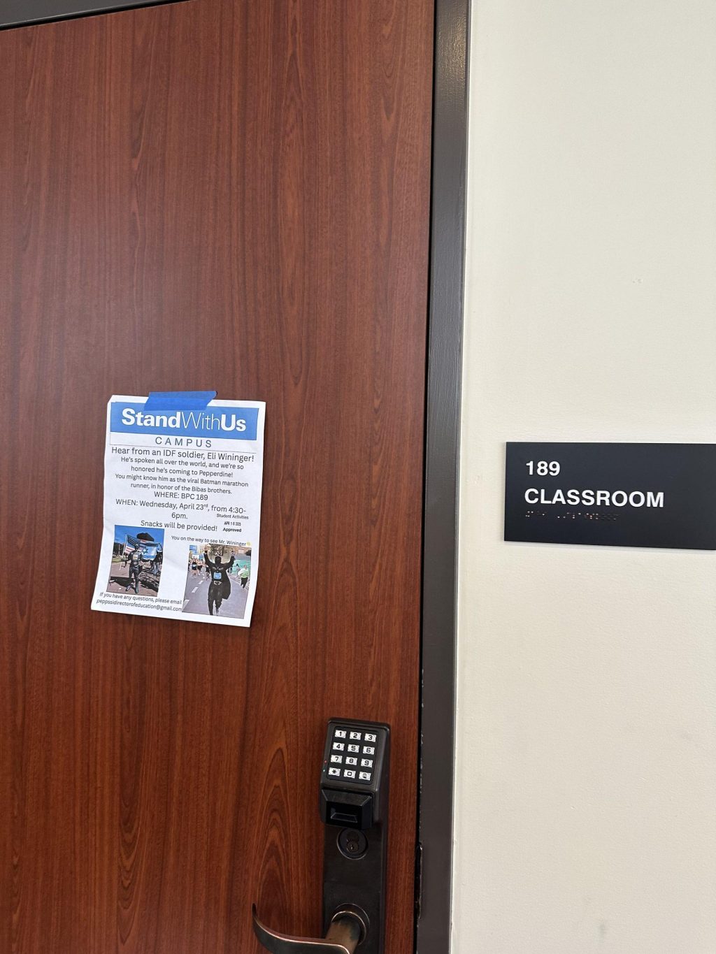 The event’s flyer rests on the door to BPC 189, where the event was held April 23. Snacks, blue sunglasses and StandWithUs booklets were placed in the back of the classroom.