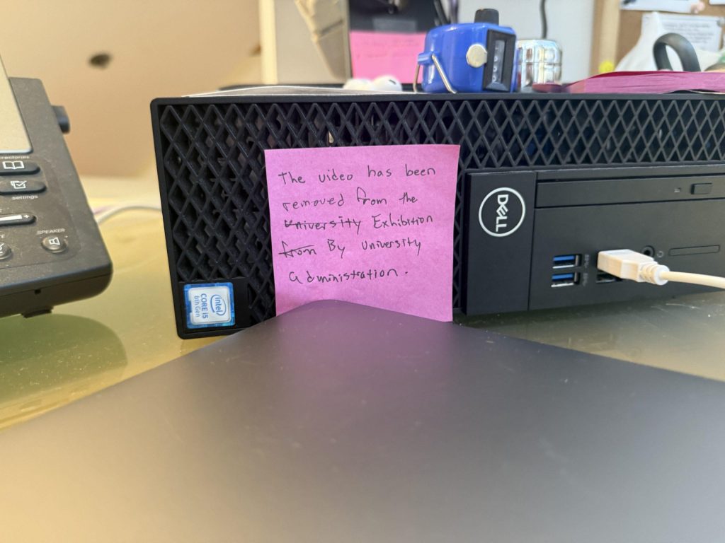 A Post-it note placed on the front desk of the Museum instructs Museum attendants on how to respond to guests who inquire about the powered-off monitor in Mann's corner of the exhibition. Museum intern and senior Art major Sam Backus said it was hard to have to explain the situation to guests. Photo by Henry Adams