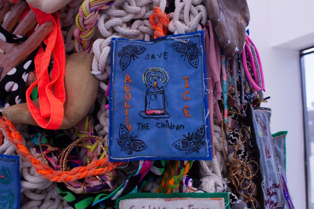 The embroidered patch Pepperdine administrators censored hangs onto the AMBOS installation in the Weisman Museum on Oct. 8. AMBOS artist Natalie Godinez said the embroidered patches across the piece were created as "amulets for protection." Photo by Griffin Pilcher