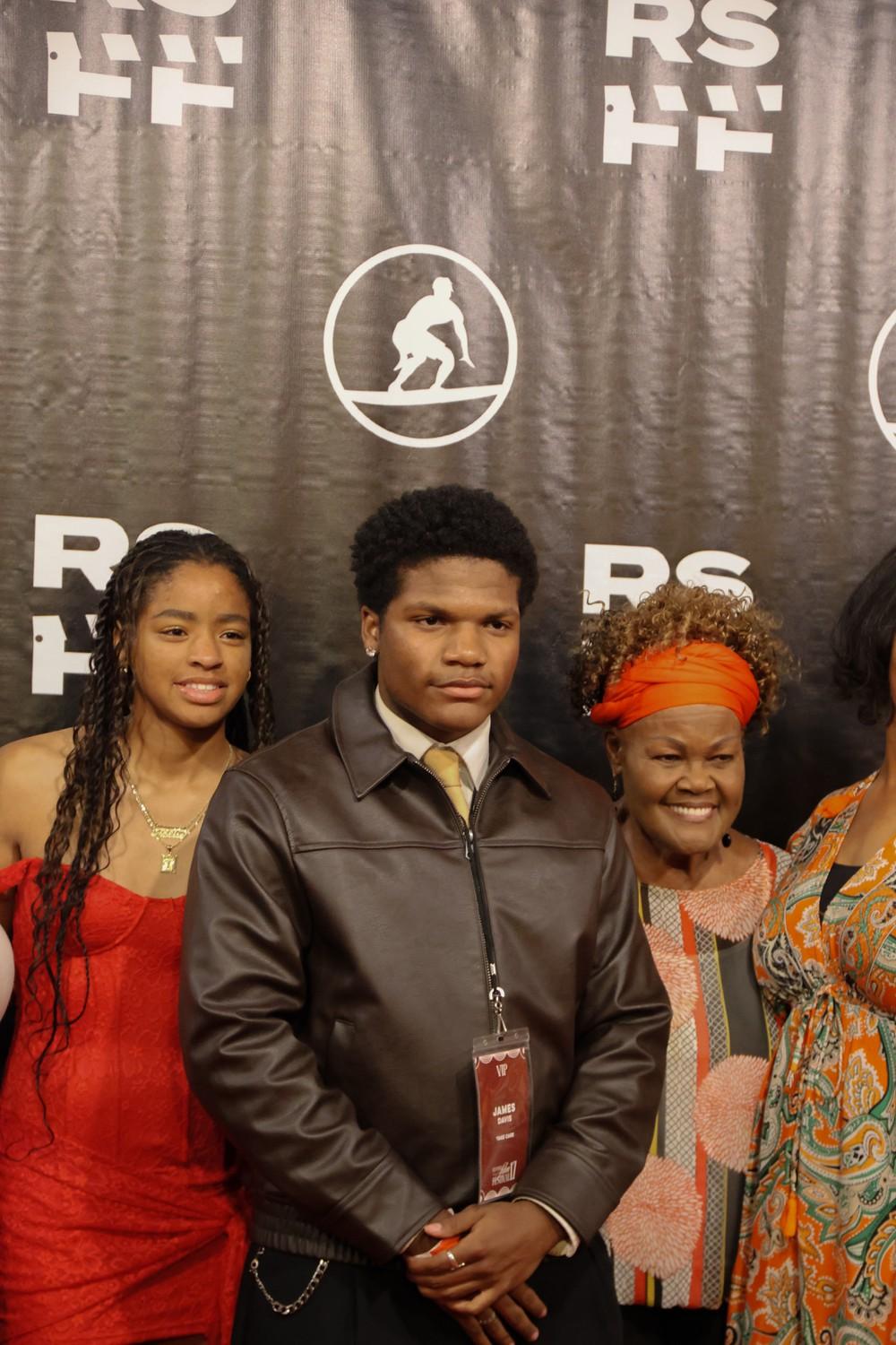 Sophomore James Davis (center) poses on the red carpet with his family at Lower Mullin Town Square on Feb. 6. He said he works as a professional actor but wants to get involved in production as well.