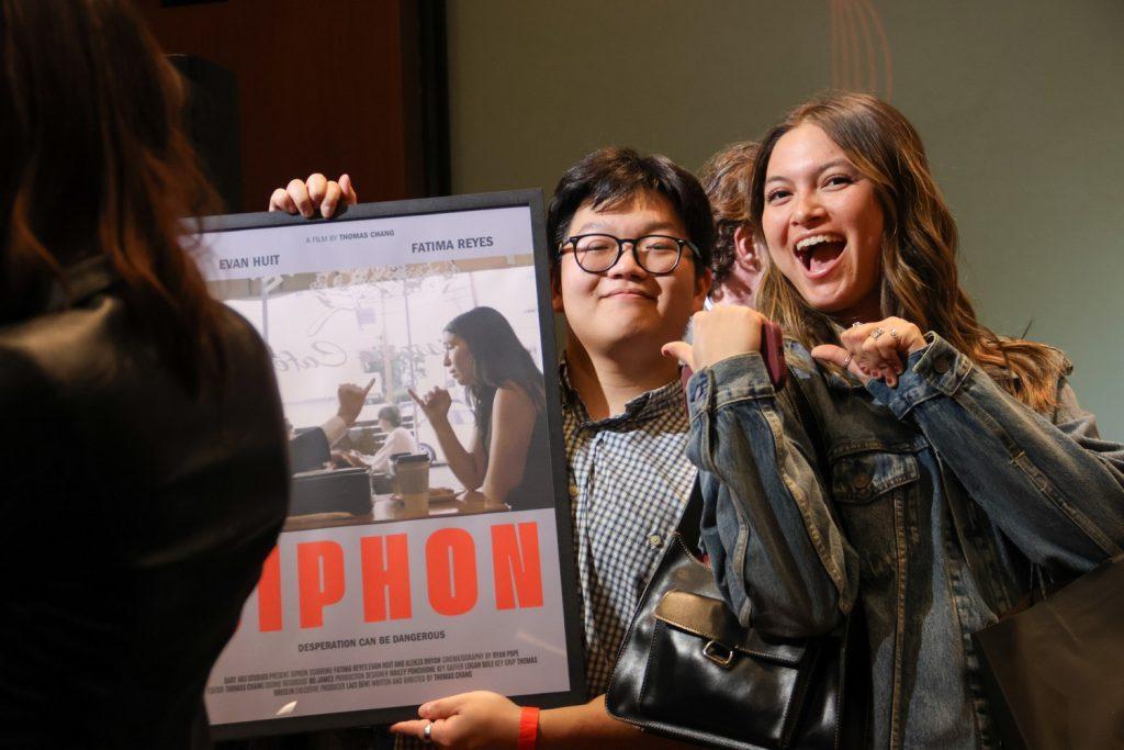 Senior Thomas Chang (left) holds up the poster for his film "SIPHON" with Amanda Monahan, the Pepperdine Graphic Creative Director (right). Senior Alekza Rhyan said Chang was a great director.