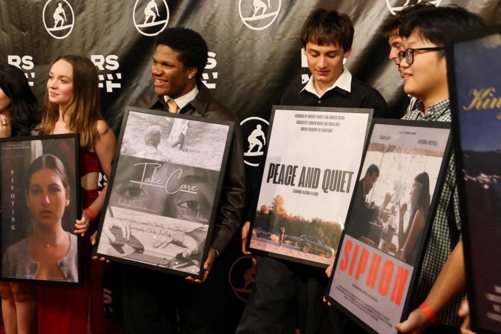 From left to right: senior Isabelle Harris, sophomore James Davis, senior Logan Bole and senior Thomas Chang pose with their film posters on the red carpet at RSF17 on Feb. 6. Harris said she felt honored to direct the crew of her film "PIVOTING." Photos by Melissa Houston